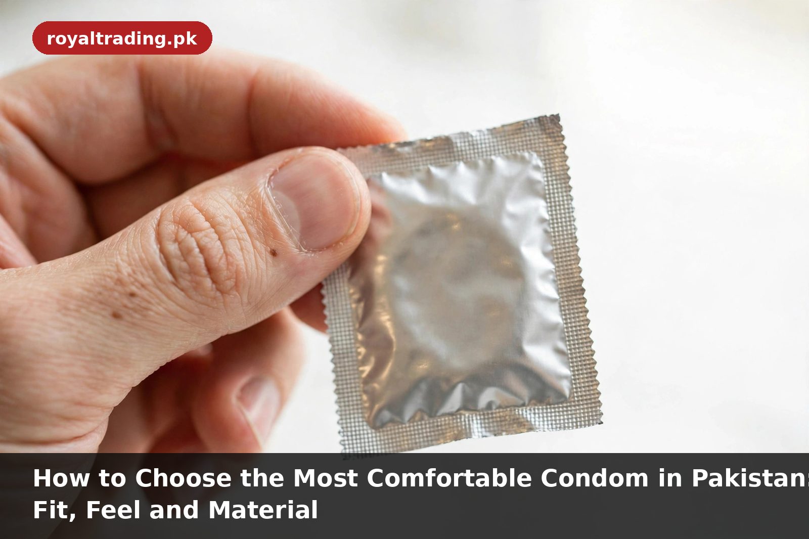 Hand holding a sealed foil condom packet